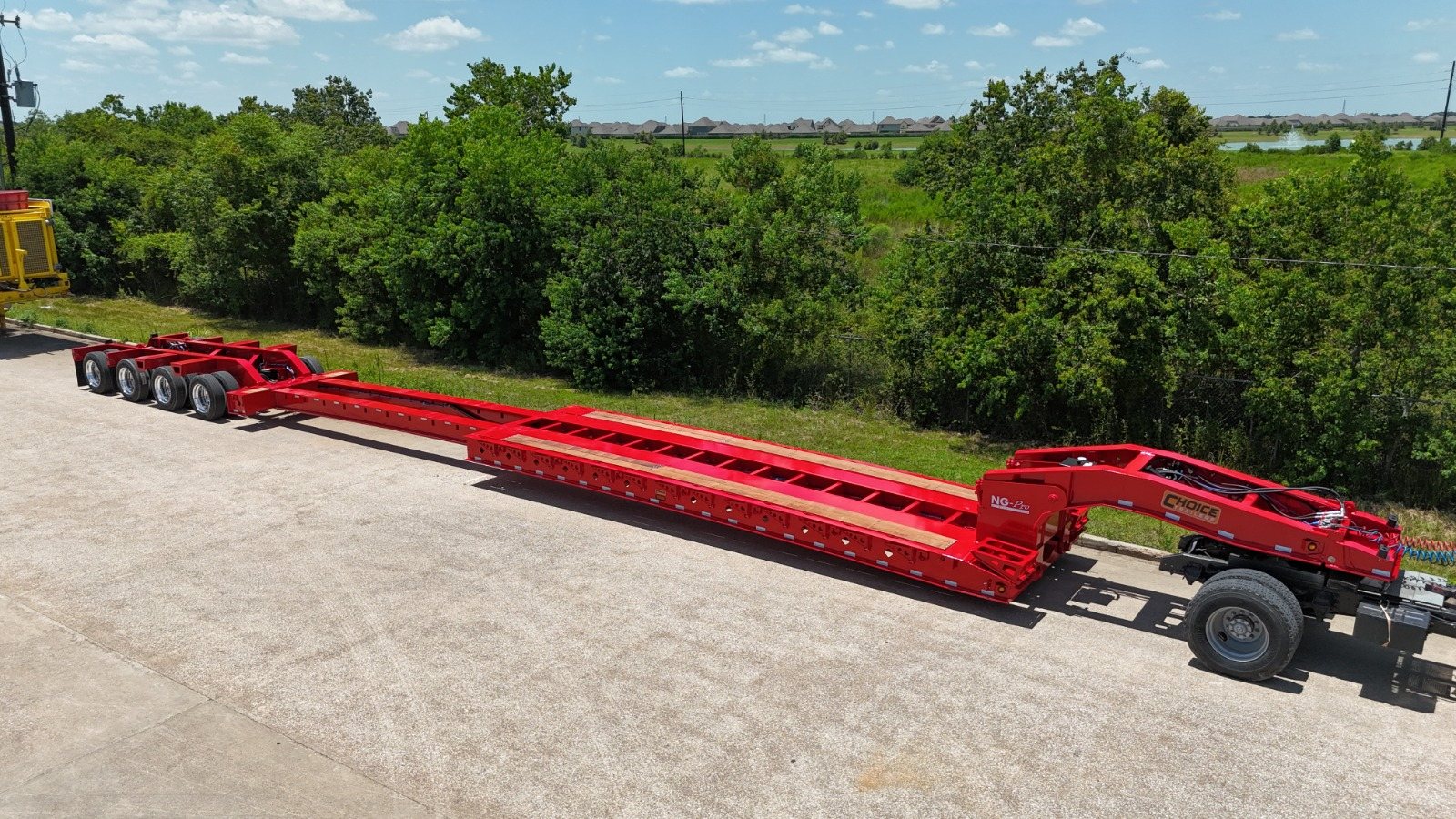 Aerial view of a red extendable lowboy coupled to a tractor