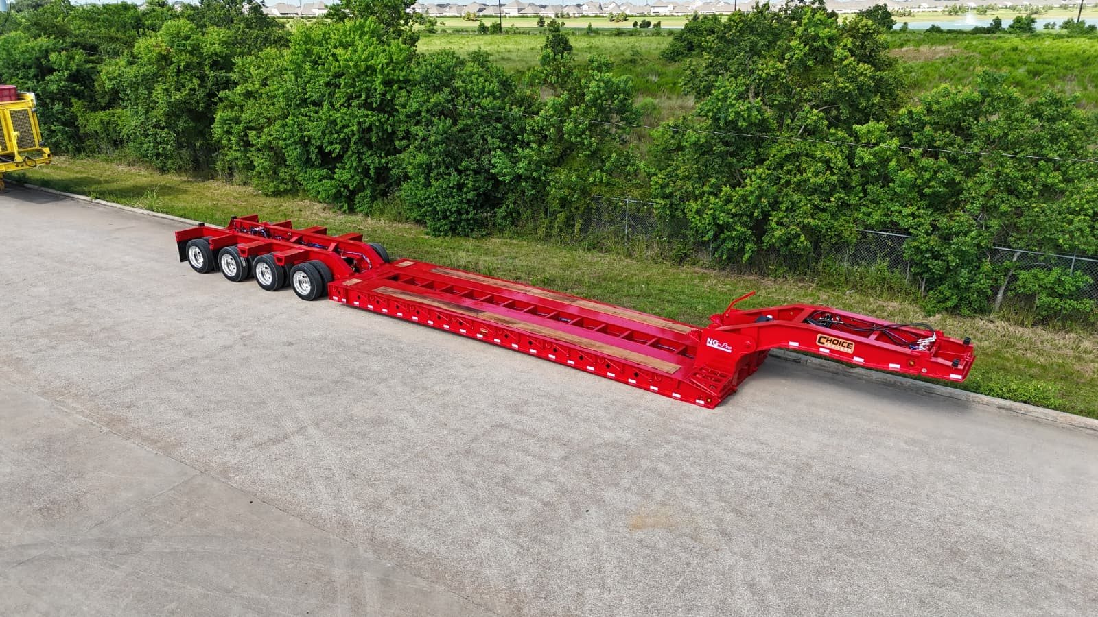 Aerial three-quarter view of a red NG-Pro Series 355NGE extendable lowboy trailer