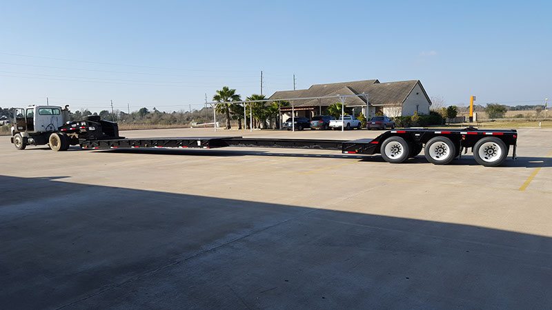 Black NG-Pro extendable lowboy hitched to a tractor on the plant lot
