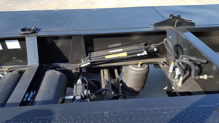 Under-deck hydraulic lines, air tanks, and control valves on a lowboy trailer